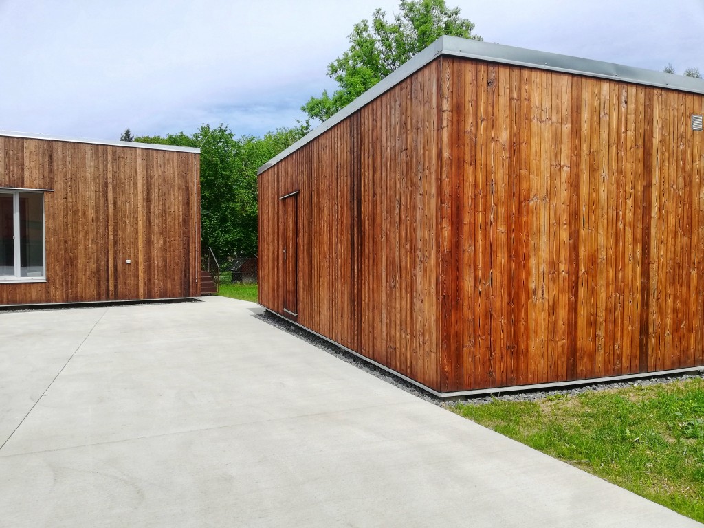 Zahradní dům s detailním pohledem na metličkovaný betonový dvůr.