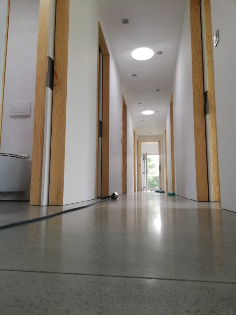 Minimalistický design: Precizní přechod podlahy a skryté detaily posuvných dveří.