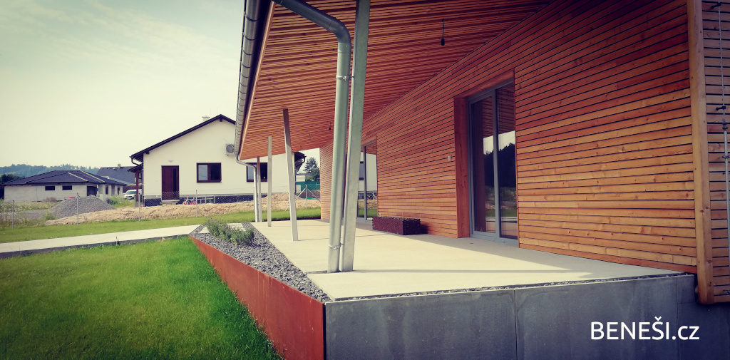 Sibiřský modřín v kombinaci s litým betonem a minimalistickou ocelovou opěrnou stěnou.